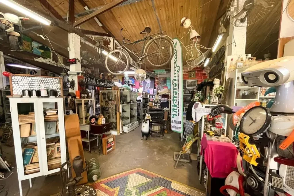 Ambiente interno do Museu do Lixo em Florianópolis, com objetos reciclados, móveis antigos e decoração sustentável.