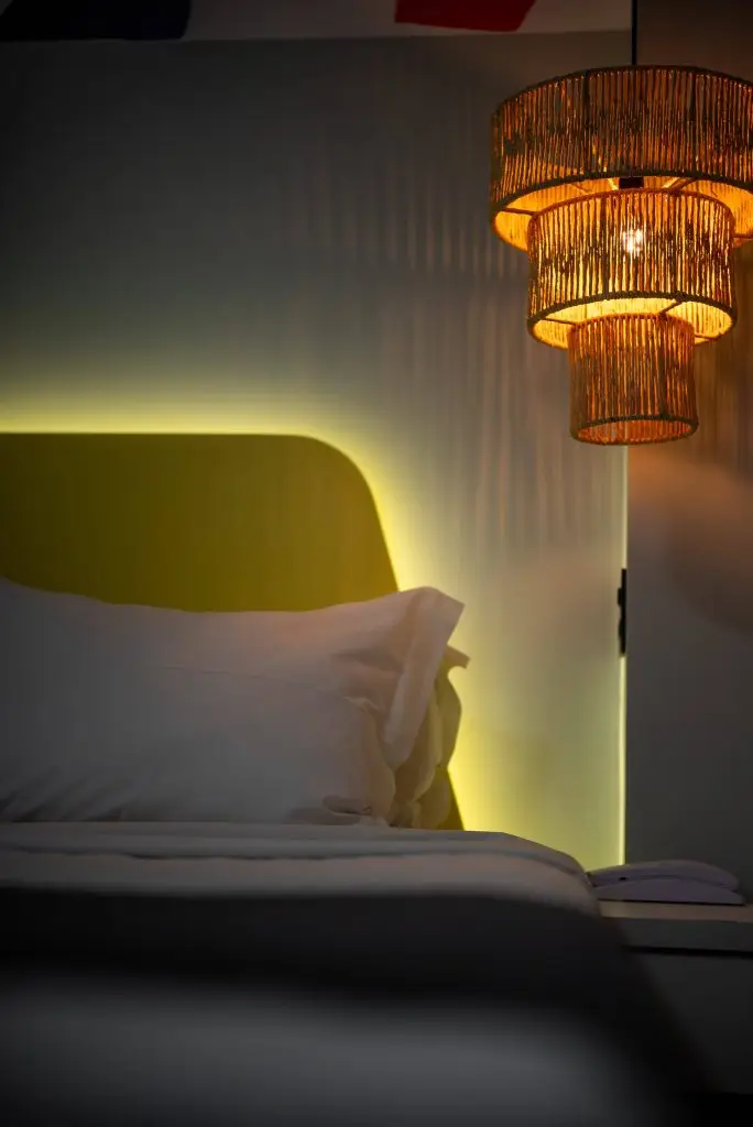 imagem da luminária ao lado da cama da suíte.